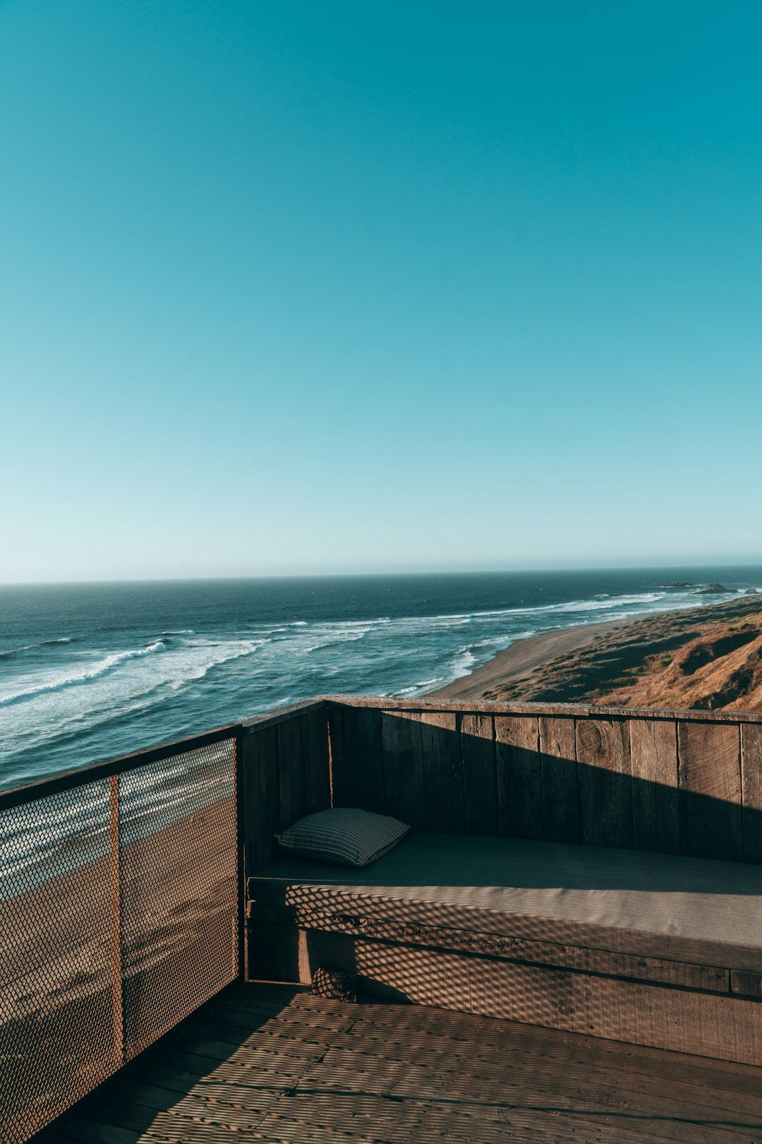 Minimalist oceanfront villa with concrete and timber facade surrounded by dunes