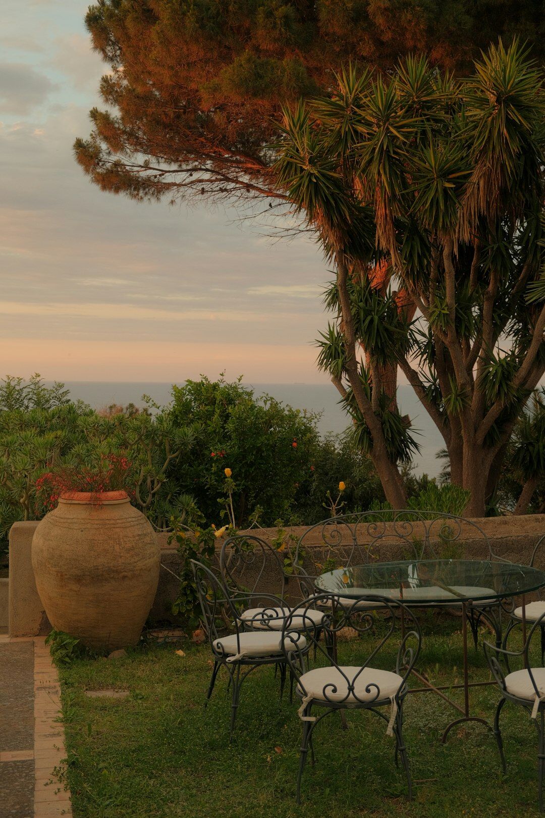 Sunset dinner table set on a terrace overlooking the ocean
